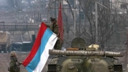 Russia/Chechnya - Russian soldier unfold state flag on an APC near Minutka square in the Chechen capital of Grozny on 9 February 2000, file photo (epa)