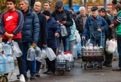 Жители Николаева стоят в очереди за водой после обстрелов города российскими войсками