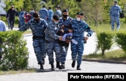 Нұр-Сұлтанда полиция көшеде ұстаған азаматты көлікке салуға апара жатыр. Бұл күні елде демократиялық реформалар жүргізуді талап етіп, наразылық акциясына шыққан жүздеген адамды полиция көшеден күштеп әкетті. Қазақстан, 6 маусым (Петр Троценко).