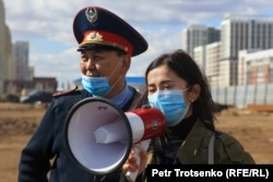 Полицейдің қасында тұрған әкімдік қызметкері. Нұр-Сұлтан, 12 қыркүйек, 2021 жыл.