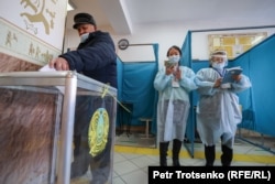 Парламент және мәслихаттар сайлауына дауыс беріп тұрған адам мен учаскелік сайлау комиссиясының мүшелері. Алматы, 10 қаңтар 2021 жыл.