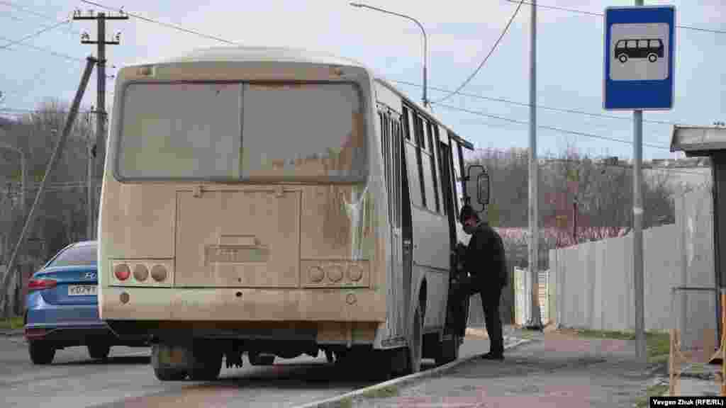 Мужчина садится в автобус для поездки в соседнее село