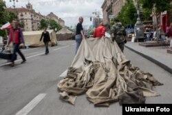 Майдан белсенділері алаңнан жинап алынған шатырды әкетіп барады. Киев, 28 мамыр 2014 жыл.