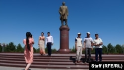 Ислам Каримовтің ескерткіші жанында тұрған адамдар. Ташкент