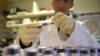 A picture taken on December 15, 2015 shows a technician holding blood samples about to be tested at the French national anti-doping laboratory, in Chatenay-Malabry, outside Paris. (Photo by FRANCK FIFE / AFP)