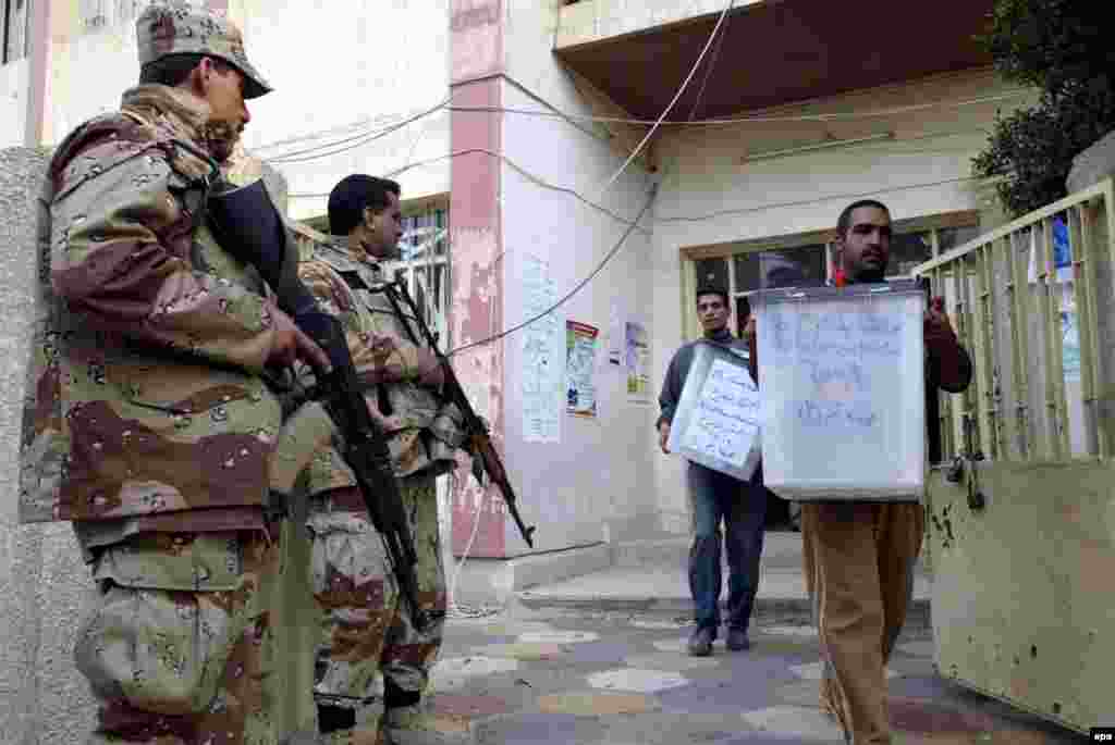 Iraqi employees of the Independent Iraqi Electoral Commission in Iraq (IECI) tansport ballot boxes from a polling station to the IECI headqurters in Baghdad on Fraiday 16 December 2005